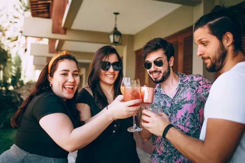 Un groupe d'amis trinque avec des boissons en plein air lors d'une fête