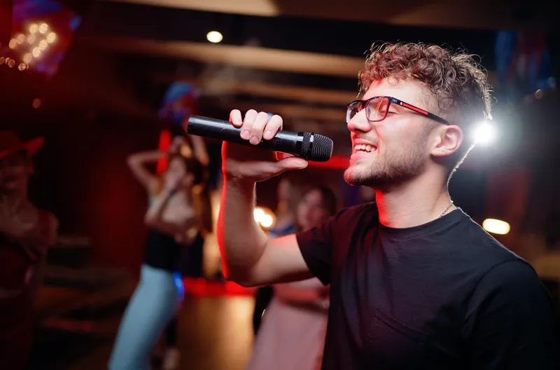Un jeune homme chante au karaoké lors d'une fête d'anniversaire